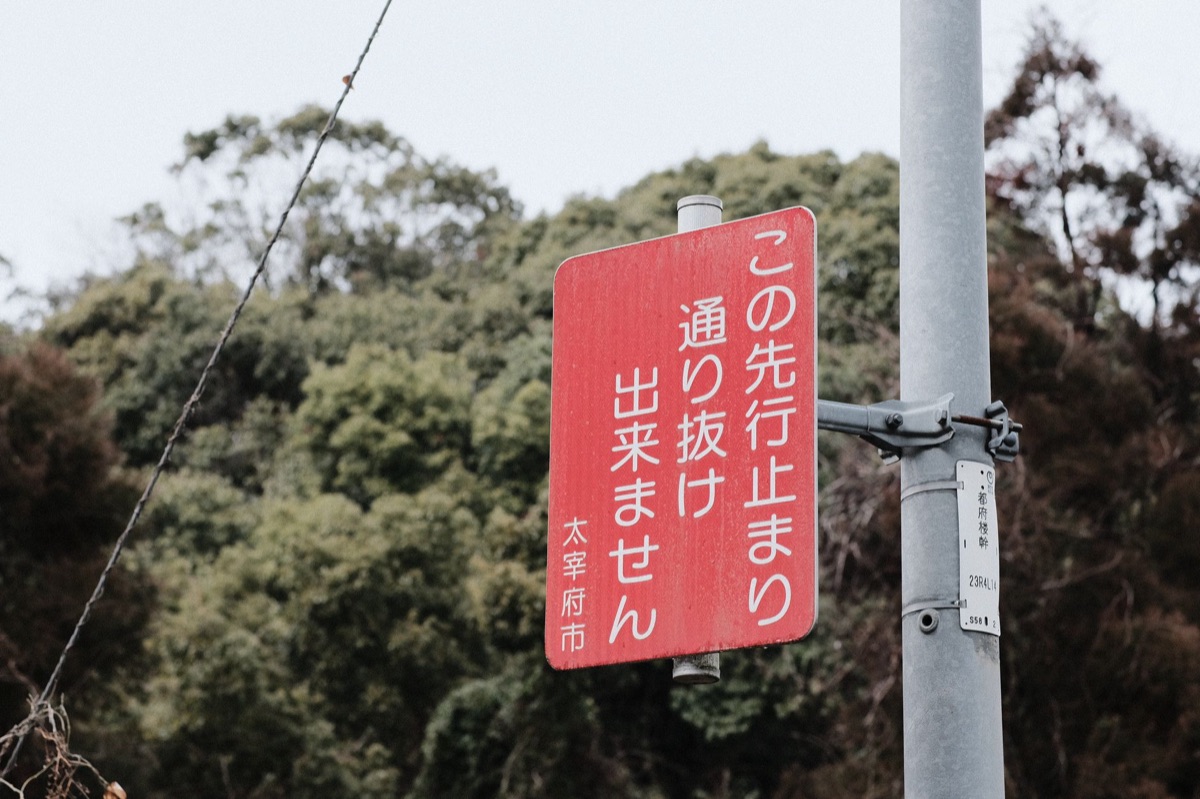 road sign with Japanese text and map in countryside