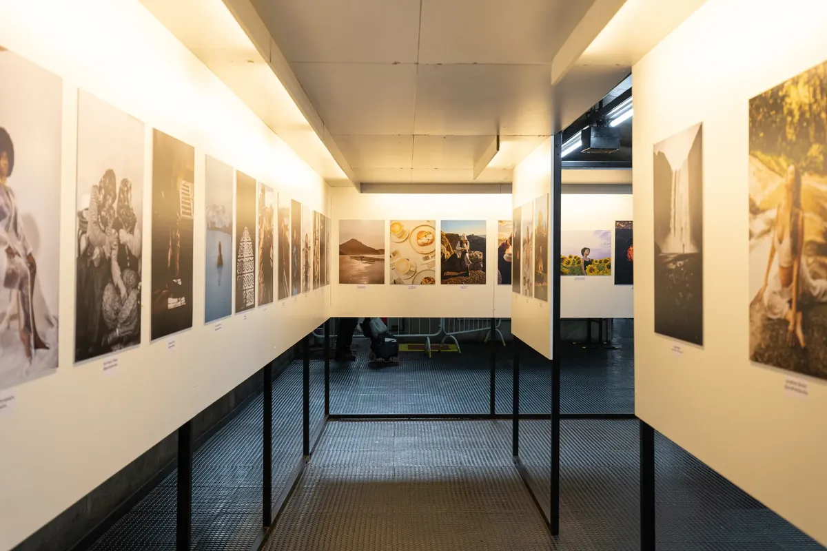 A well-lit art exhibition featuring diverse photographic prints in a modern indoor gallery.