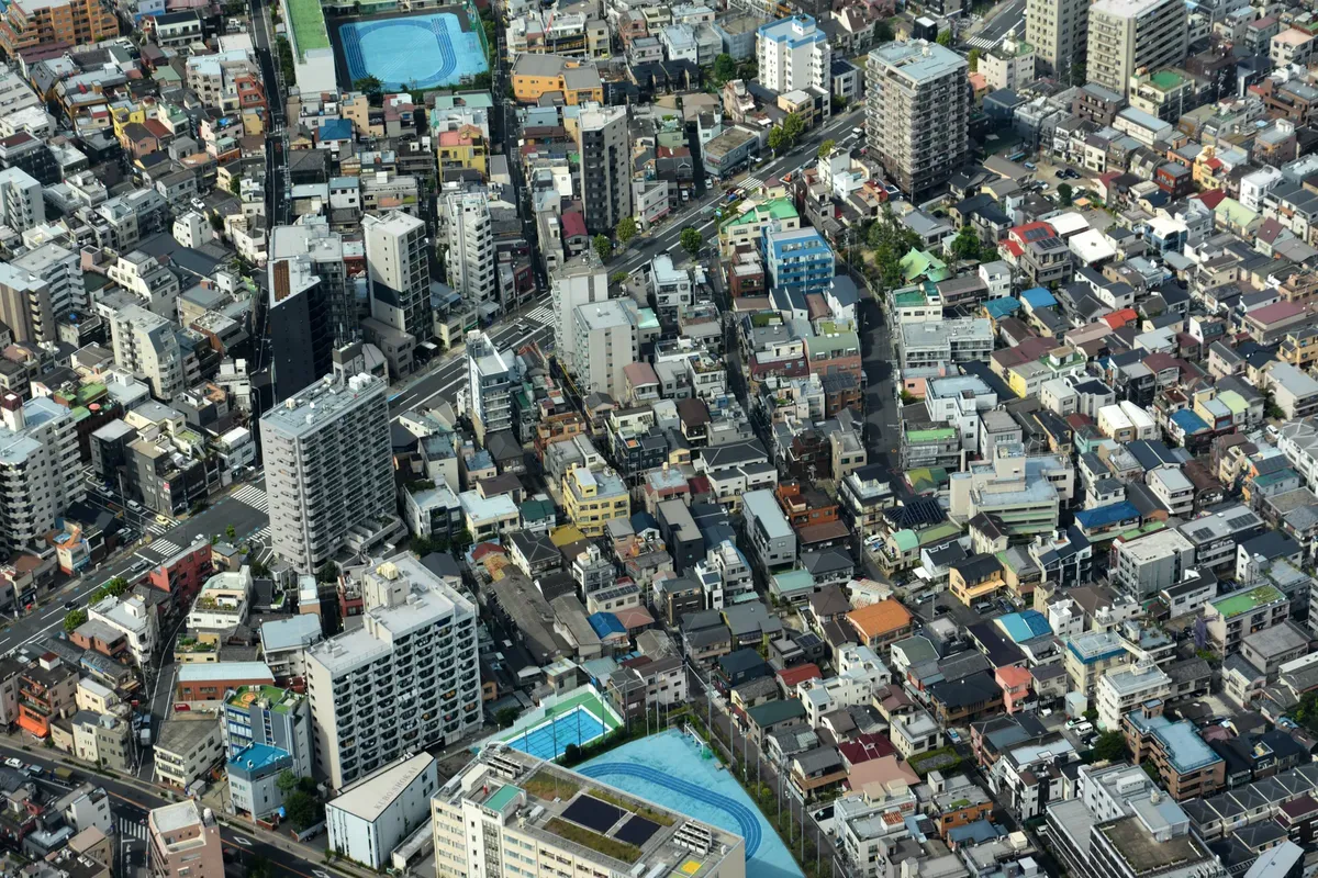 Aerial view highlighting Tokyo's dense urban residential area with mixed housing types.